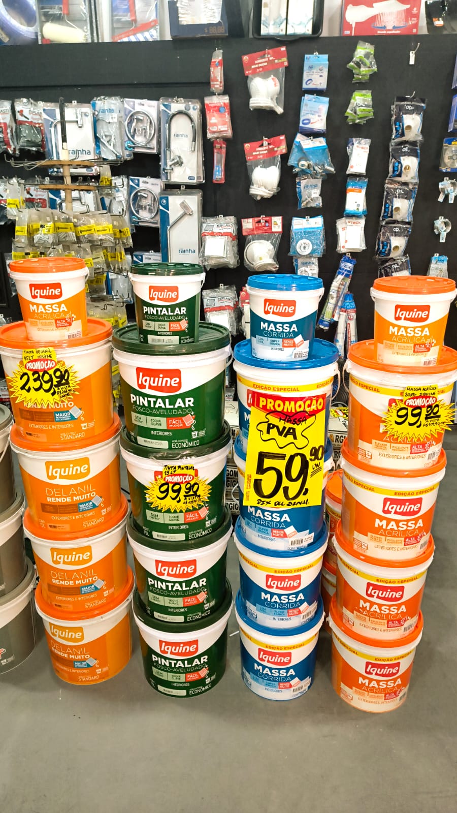 Latas de tinta e massa Iquine em exposição com preços de promoção